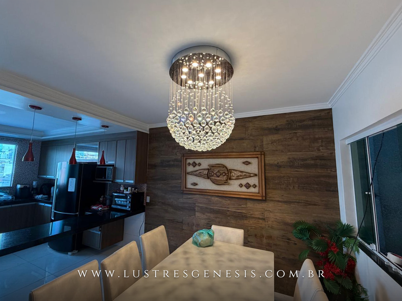 Lustre de cristal em formato de esfera com diâmetro de 60cm iluminando uma sala de jantar elegante. Lustres Gênesis loja online de Lustres e Iluminação Decorativa